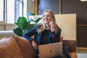 Woman speaking on the phone, in front of a laptop